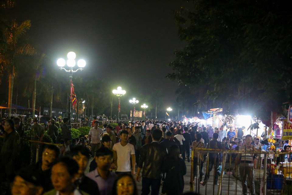 Chen chúc trong biển người, anh Nguyễn Minh Đức (Hải Hậu, Nam Định) cho hay: 'Mặc dù nhà ở xa, nhưng đã thành thường lệ, năm nào mấy anh em chúng tôi cũng tổ chức xuống khai ấn, mong một năm làm ăn phát đạt. Mình cố chen vào đền, lấy được lá ấn ngay trong đêm Rằm mới thiêng.'(Ảnh: PV/Vietnam+)