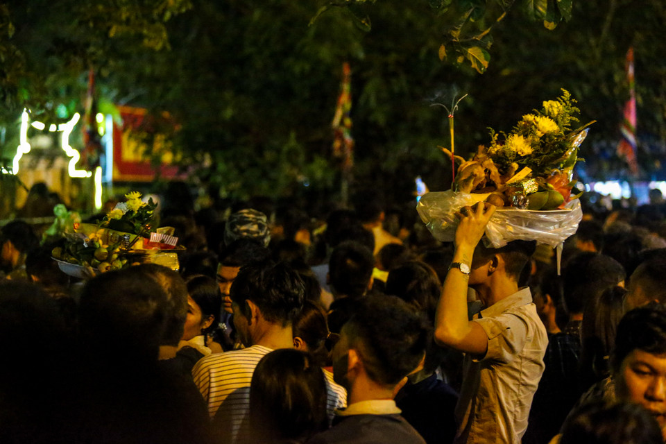 Càng gần đến giờ khai Ấn, lượng người đổ về khu vực đền chính mỗi lúc một đông hơn. Đường Trần Thừa – con đường dẫn vào Đền kín đặc người cùng những mâm lễ được sắp gọn gàng. (Ảnh: PV/Vietnam+)