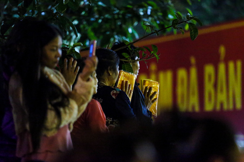 Nhiều người đã có sẵn ấn từ trước và tranh thủ vái vọng vào khu vực đền và chờ đến giờ làm lễ. (Ảnh: PV/Vietnam+)