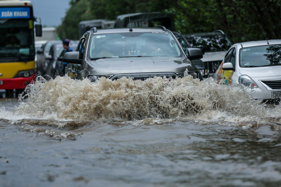 Nếu muốn tránh đoạn đường ngập, các phương tiện phải quay đầu xe đi ngược chiều hoặc phải tiếp tục đi qua. (Ảnh: Minh Sơn/Vietnam+)