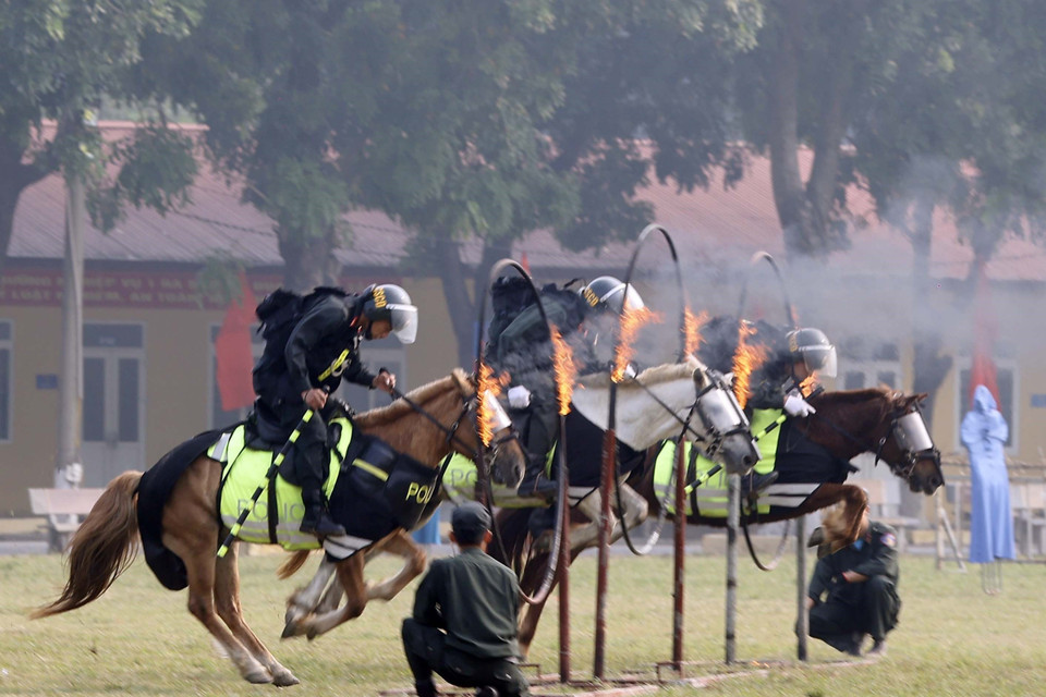 Các chiến sỹ Cảnh sát Cơ động Kỵ binh biểu diễn nhảy qua vòng lửa. (Ảnh: Thống Nhất/TTXVN)