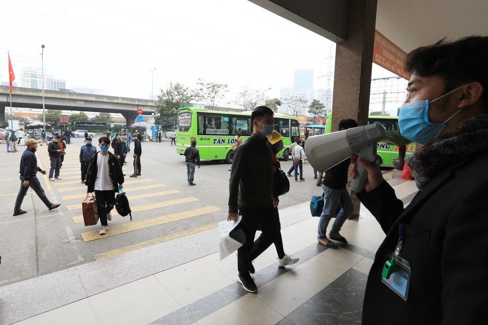 Lực lượng chức năng của bến xe Mỹ Đình nhắc nhở người dân đeo khẩu trang phòng chống dịch. (Ảnh: Thành Đạt/TTXVN)