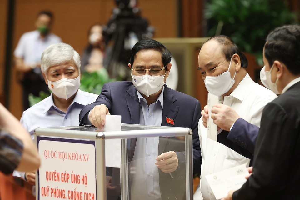 Chủ tịch nước Nguyễn Xuân Phúc, Thủ tướng Phạm Minh Chính và các đại biểu Quốc hội quyên góp ủng hộ Quỹ phòng, chống dịch COVID-19. (Ảnh: Dương Giang/TTXVN)