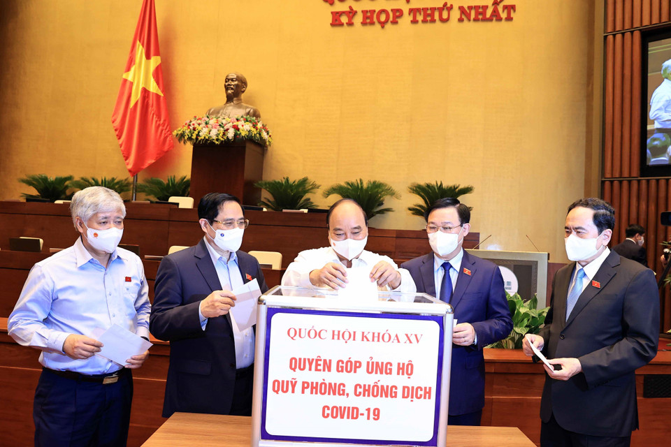 Chủ tịch nước Nguyễn Xuân Phúc, Thủ tướng Phạm Minh Chính, Chủ tịch Quốc hội Vương Đình Huệ và các đại biểu Quốc hội quyên góp ủng hộ Quỹ phòng chống dịch COVID-19. (Ảnh: Thống Nhất/TTXVN)