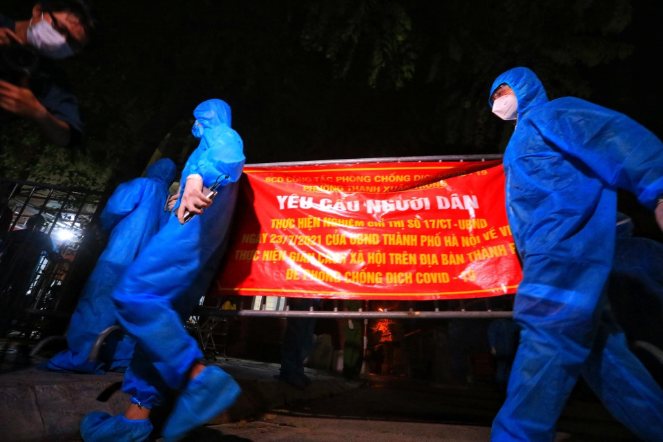 Lực lượng tình nguyện viên gỡ bỏ rào chắn tại ngõ 328, 330 đường Nguyễn Trãi. (Ảnh: Tuấn Anh/TTXVN)