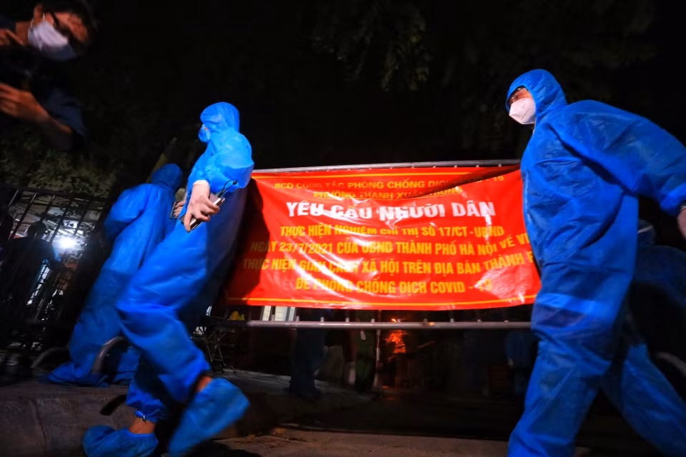 Lực lượng tình nguyện viên gỡ bỏ rào chắn tại ngõ 328, 330 đường Nguyễn Trãi. (Ảnh: Tuấn Anh/TTXVN)