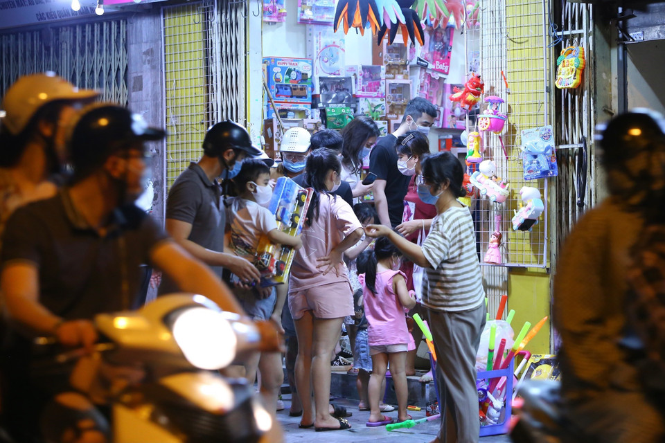 Lúc 22h35, người dân tập trung đông, không giữ khoảng cách an toàn phòng dịch tại một cửa hàng bán đồ Trung Thu trên phố Lương Văn Can. (Ảnh: Hoàng Hiếu/TTXVN)