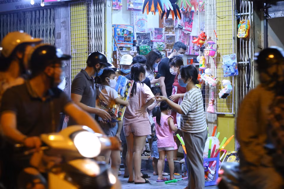 Lúc 22h35, người dân tập trung đông, không giữ khoảng cách an toàn phòng dịch tại một cửa hàng bán đồ Trung Thu trên phố Lương Văn Can. (Ảnh: Hoàng Hiếu/TTXVN)