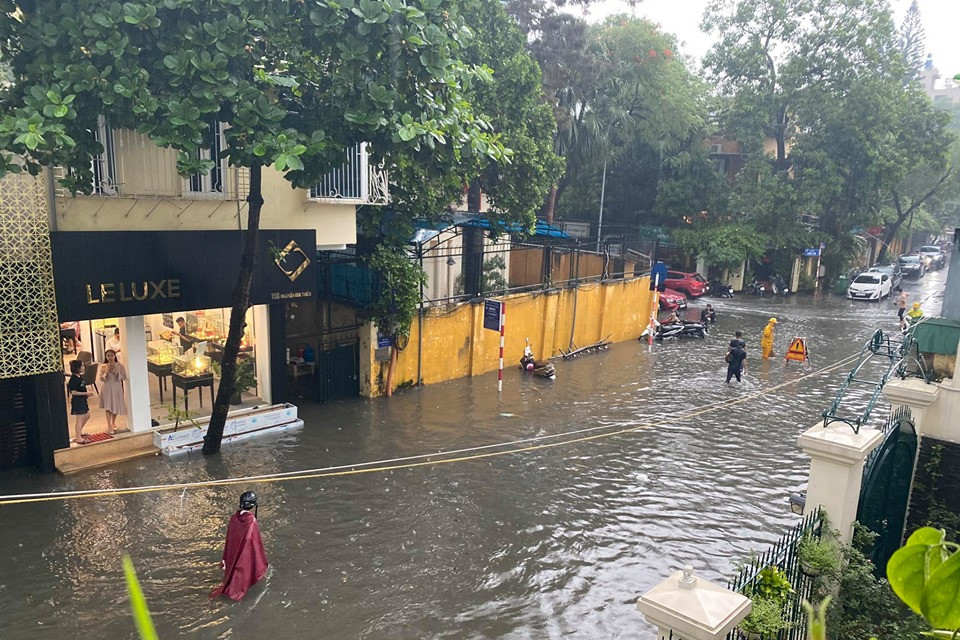 Người dân phải lội bì bõm trong dòng nước bẩn. (Ảnh: Vietnam+)