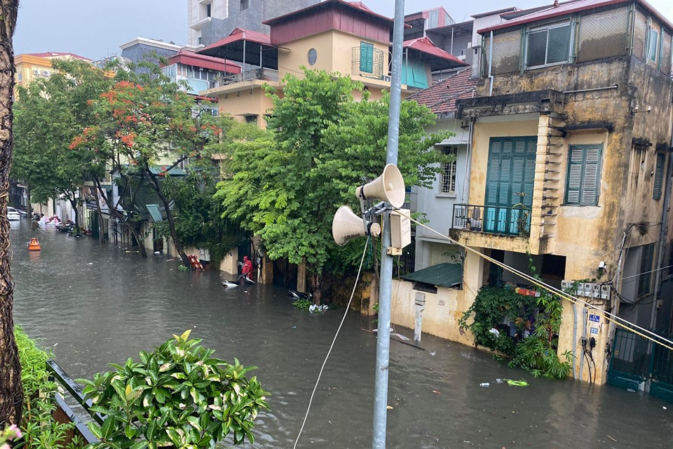 Nước mưa cùng nước thải đục ngầu tràn vào nhiều nhà dân ven đường. (Ảnh: Vietnam+)