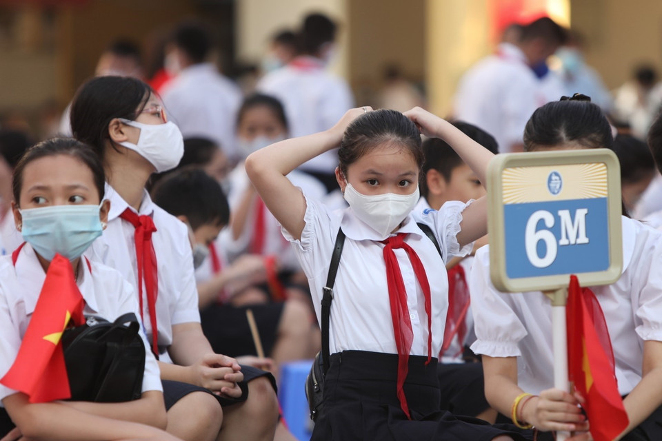 Học sinh khối lớp 6 trường THCS Trưng Vương, quận Hoàn Kiếm dự lễ khai giảng trực tiếp tại sân trường. (Ảnh: Danh Lam/TTXVN)