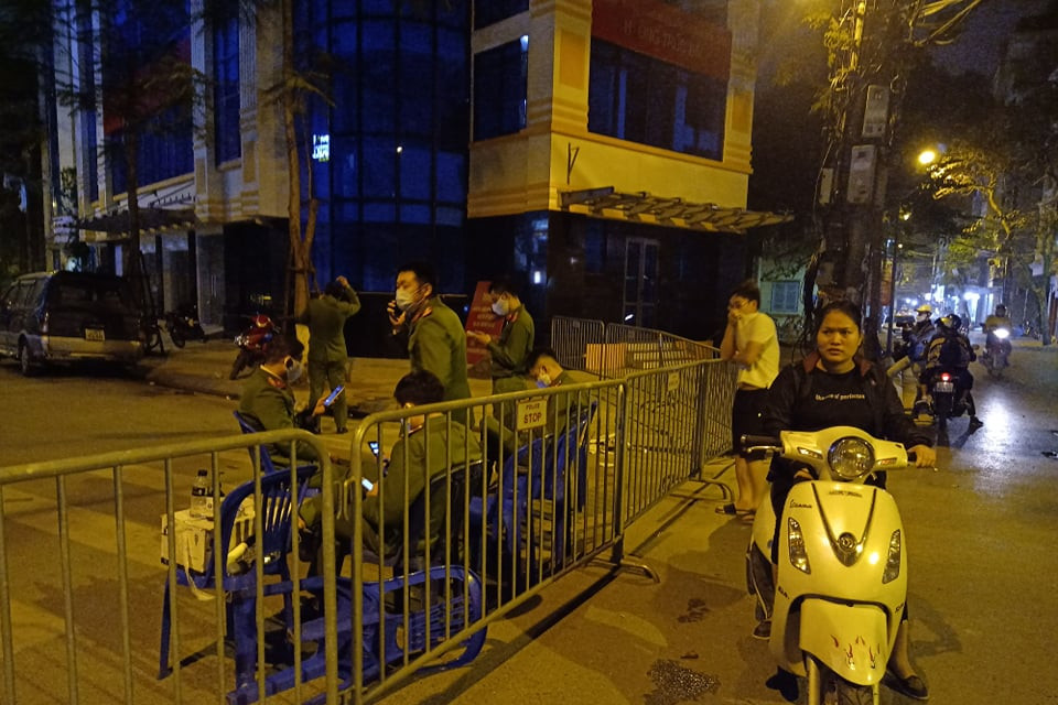 Cảnh sát được huy động, và đều bịt kín khẩu trang y tế. Rất đông người dân hiếu kỳ đã tập trung. (Ảnh: Sơn Bách/Vietnam+)
