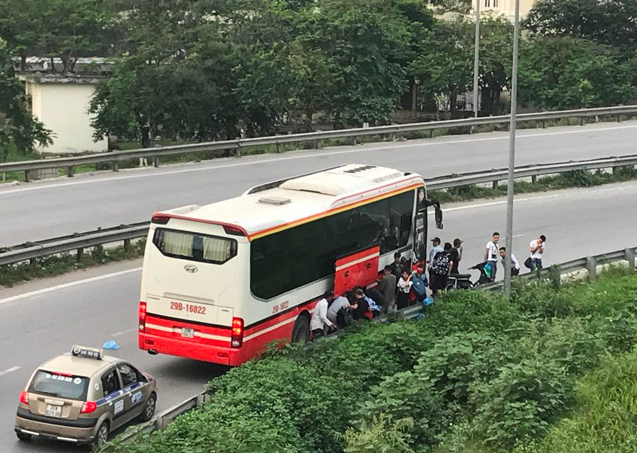 Nhà xe trả khách sai quy định ngay tại nút giao vòng lên đường vành đai 3 trên cao. (Ảnh: Việt Hùng/Vietnam+)