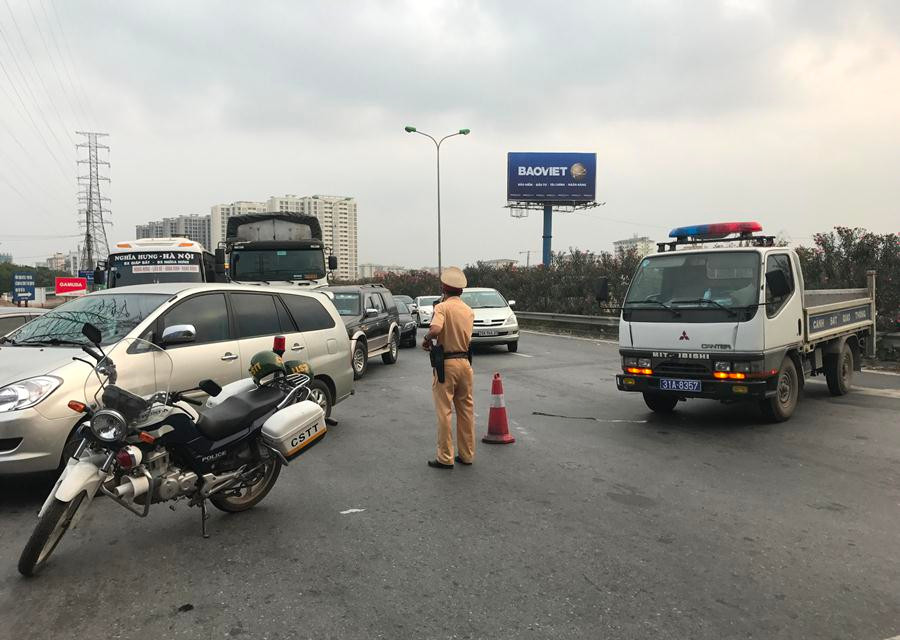 Lực lượng Cảnh sát giao thông phân luồng bằng cách cho phương tiện vòng qua đường Tam Trinh rồi mới vào đường Giải Phóng. (Ảnh: Việt Hùng/Vietnam+)