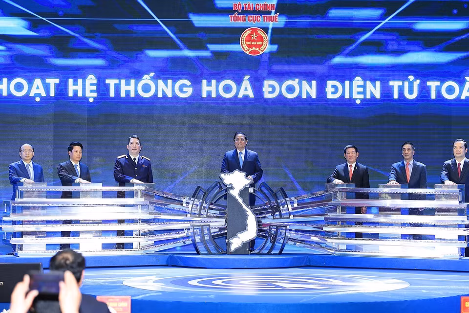 Thủ tướng Phạm Minh Chính và lãnh đạo Bộ Tài chính và Tổng Cục thuế thực hiện nghi thức kích hoạt Hệ thống hoá đơn điện tử toàn quốc. (Ảnh: Dương Giang/TTXVN)