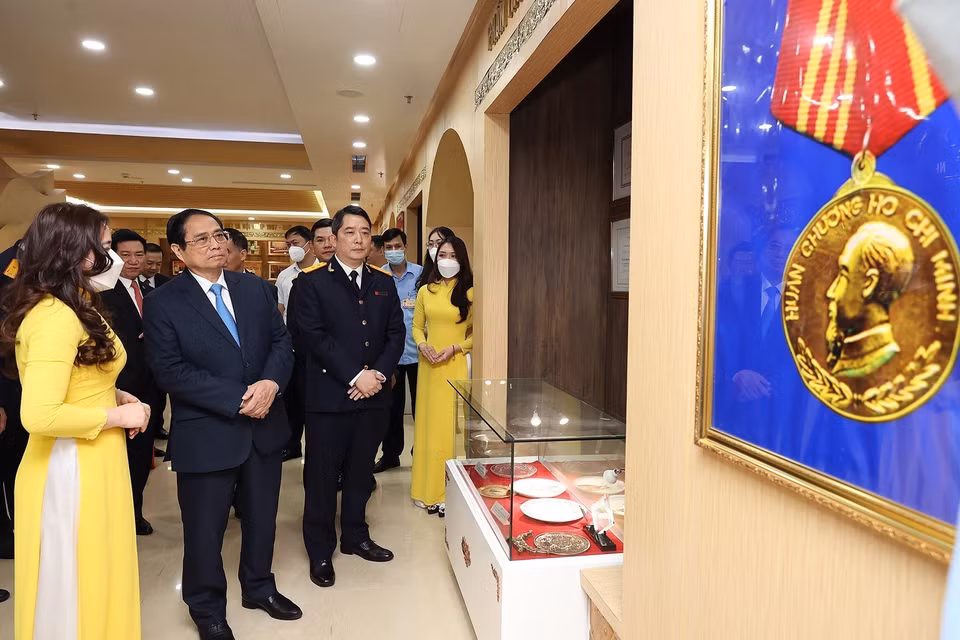 Thủ tướng Phạm Minh Chính tham quan Phòng truyền thống của Tổng Cục thuế. (Ảnh: Dương Giang/TTXVN)