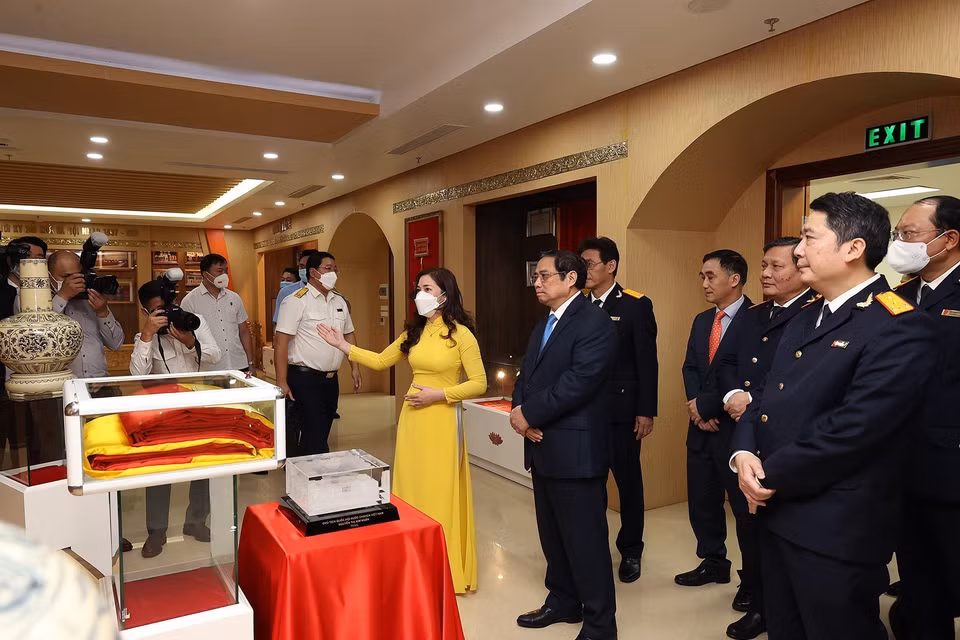 Thủ tướng Phạm Minh Chính tham quan Phòng truyền thống của Tổng Cục thuế. (Ảnh: Dương Giang/TTXVN)