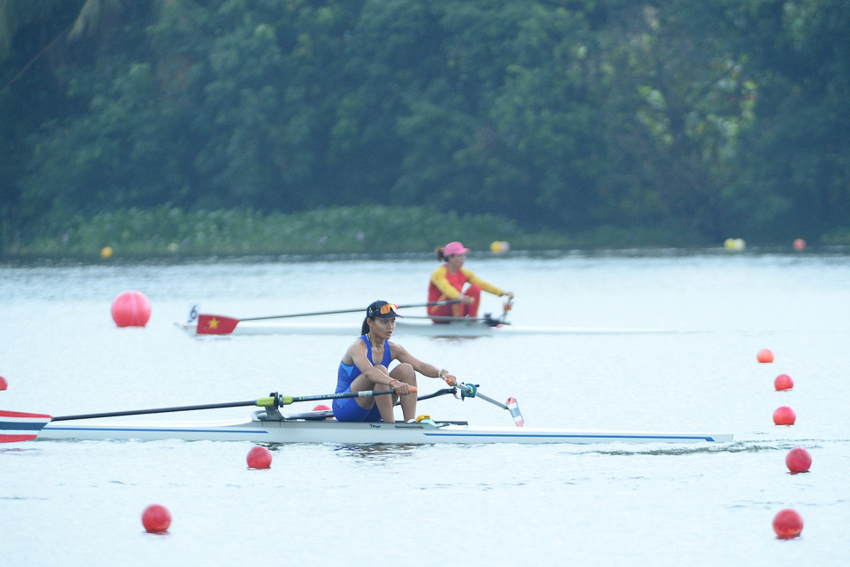 Vận động viên đội tuyển Thái Lan (gần, đường đua 2) và đội tuyển Việt Nam (xa, đường đua 6) thi đấu nội dung thuyền đơn nữ hạng nặng hai mái chèo (W1X). (Ảnh: Minh Đức/TTXVN)