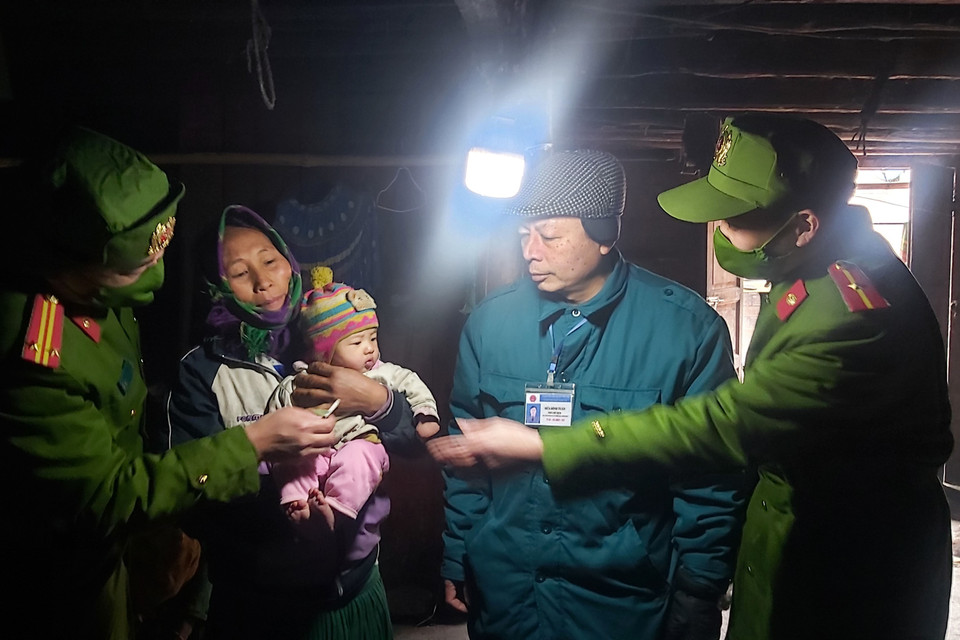 Cán bộ và công an xã Xín Cái đi tuyên truyền cho người dân giữ ấm và tặng áo ấm cho trẻ tại thôn Lùng Thúng, xã Xín Cái, huyện Mèo Vạc (Hà Giang). (Ảnh: Nguyễn Chiến/TTXVN)