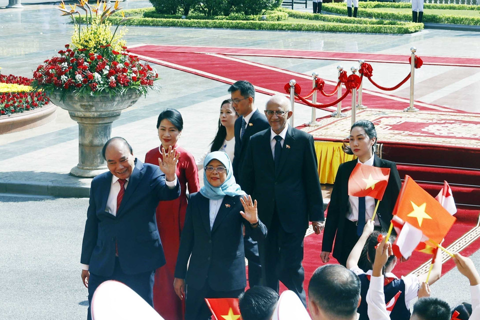 Chủ tịch nước Nguyễn Xuân Phúc và Phu nhân cùng Tổng thống Cộng hòa Singapore Halimah Yacob và Phu quân tại lễ đón. (Ảnh: Thống Nhất/TTXVN)