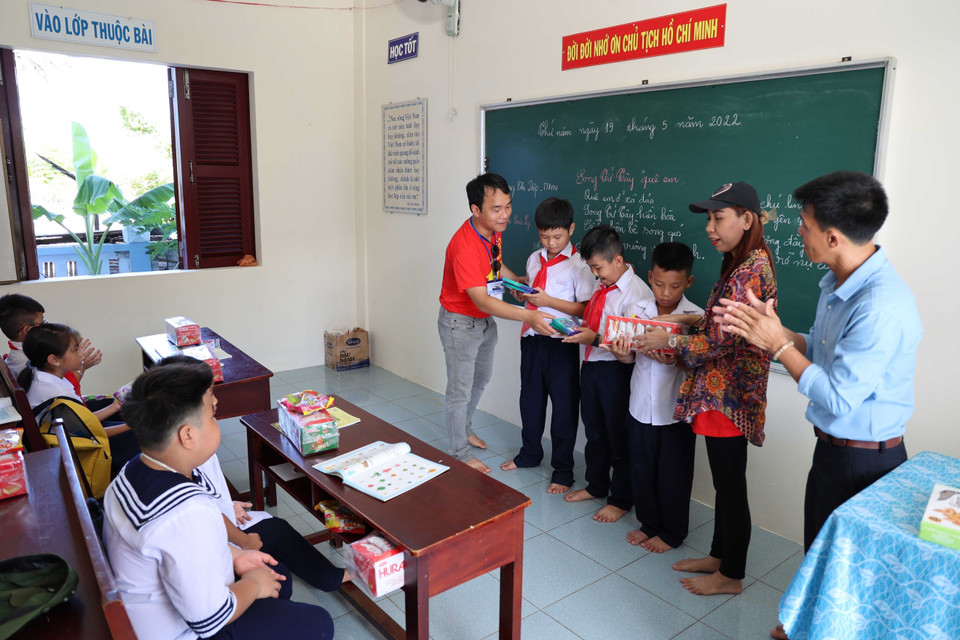 Các kiều bào tặng quà cho học sinh trường Tiểu học xã Song Tử Tây, huyện đảo Trường Sa, tỉnh Khánh Hòa. (Ảnh: Diệp Trương/TTXVN)