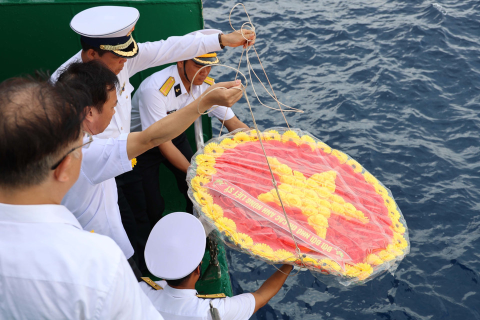 Các đại biểu kiều bào tham dự Lễ tưởng niệm cán bộ, chiến sỹ hy sinh tại quần đảo Trường Sa vì sự nghiệp bảo vệ chủ quyền biển, đảo Tổ quốc trong không khí nghiêm trang và xúc động tại boong tàu Trường Sa 571. (Ảnh: Diệp Trương/TTXVN)