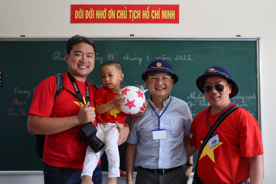 Các kiều bào tặng quà cho học sinh trường Tiểu học xã Song Tử Tây, huyện đảo Trường Sa, tỉnh Khánh Hòa. (Ảnh: Diệp Trương/TTXVN)