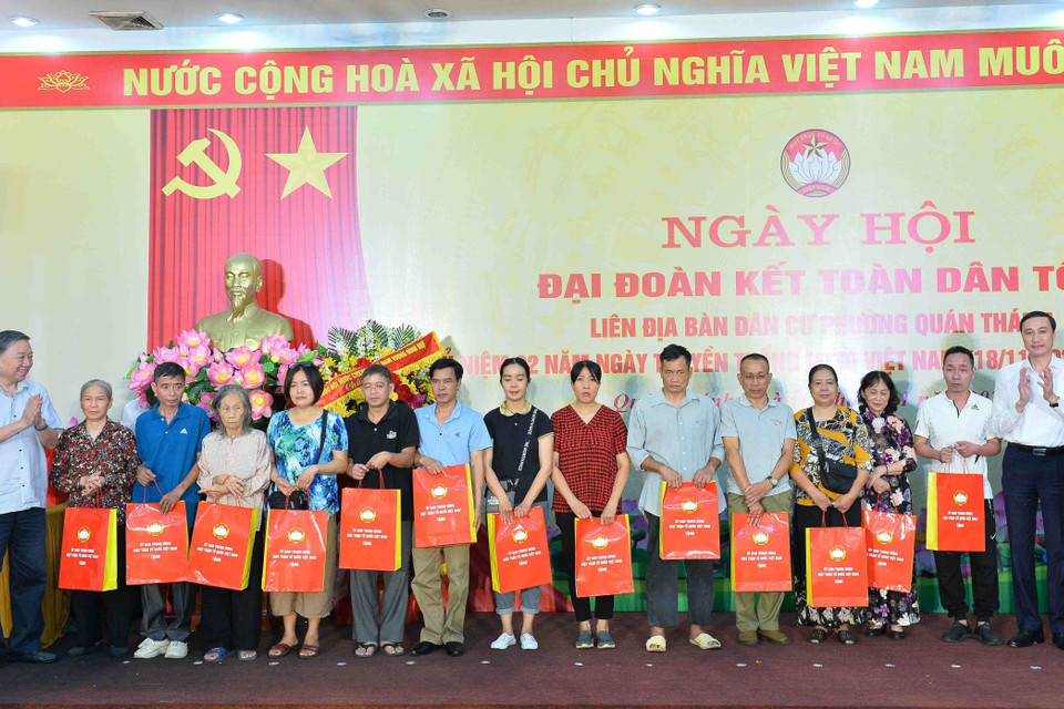 Đại tướng Tô Lâm, Bộ trưởng Bộ Công an, và Phó Chủ tịch Ủy ban Trung ương Mặt trận Tổ quốc Việt Nam Phùng Khánh Tài tặng quà cho các hộ gia đình có hoàn cảnh khó khăn. (Ảnh: Minh Đức/TTXVN)