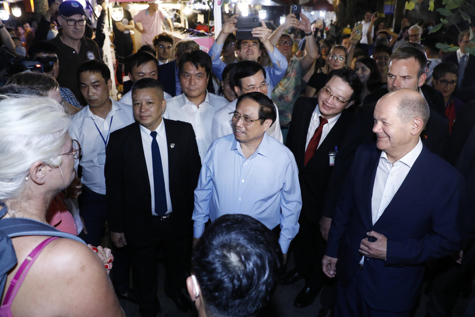 Thủ tướng Phạm Minh Chính và Thủ tướng Đức Olaf Scholz trò chuyện với khách quốc tế tại khu vực bờ hồ Hoàn Kiếm.(Ảnh: An Đăng/TTXVN)