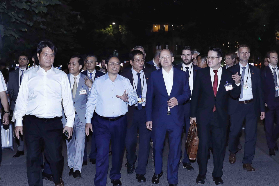 Thủ tướng Phạm Minh Chính và Thủ tướng Đức Olaf Scholz đi bộ bên bờ hồ Hoàn Kiếm. (Ảnh: An Đăng/TTXVN)