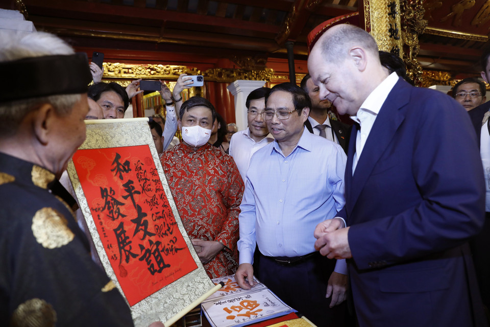 Thủ tướng Phạm Minh Chính giới thiệu bức thư pháp tới Thủ tướng Đức Olaf Scholz tại đền Ngọc Sơn. (Ảnh: An Đăng/TTXVN)