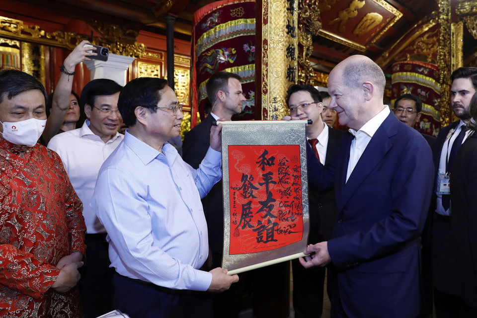 Thủ tướng Phạm Minh Chính tặng Thủ tướng Đức Olaf Scholz bức thư pháp với nội dung "Hòa bình - Hữu nghị cùng phát triển" tại đền Ngọc Sơn. (Ảnh: An Đăng/TTXVN)