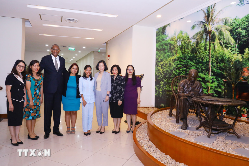Tổng Giám đốc Thông tấn xã Việt Nam Vũ Việt Trang, Phó Tổng Biên tập báo Granma (Cuba) Arlin Alberty Loforte và các đại biểu chụp ảnh chung bên bức tượng Chủ tịch Hồ Chí Minh. (Ảnh: Văn Điệp/TTXVN)