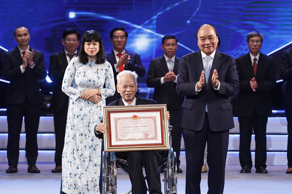 Chủ tịch nước Nguyễn Xuân Phúc trao Giải thưởng Hồ Chí Minh cho Giáo sư, Tiến sỹ khoa học Nguyễn Quang Hồng, tác giả công trình "Tự điển chữ Nôm dẫn giải". (Ảnh: Thống Nhất/TTXVN)