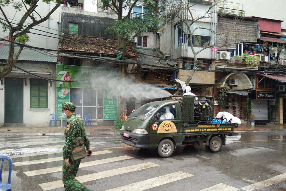 Phun thuốc tiêu độc khử trùng các hộ dân xung quanh khu vực nơi có bệnh nhân bị dương tính với COVID-19. (Ảnh: Sơn Bách/Vietnam+)