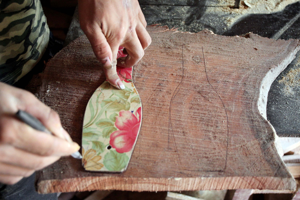 Đầu tiên, người thợ phải tạo hình khuôn lên tấm gỗ. (Ảnh: Doãn Đức/Vietnam+)