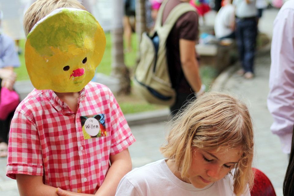 Cậu bé William ​'góp ý' với chị sau khi đã hoàn thành chiếc mặt nạ của mình.(Ảnh: Doãn Đức/Vietnam+)