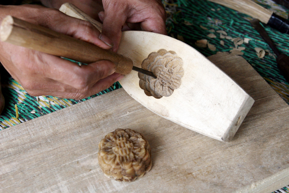 Tạo hình cho khuôn bánh theo mẫu của người đặt. (Ảnh: Doãn Đức/Vietnam+)