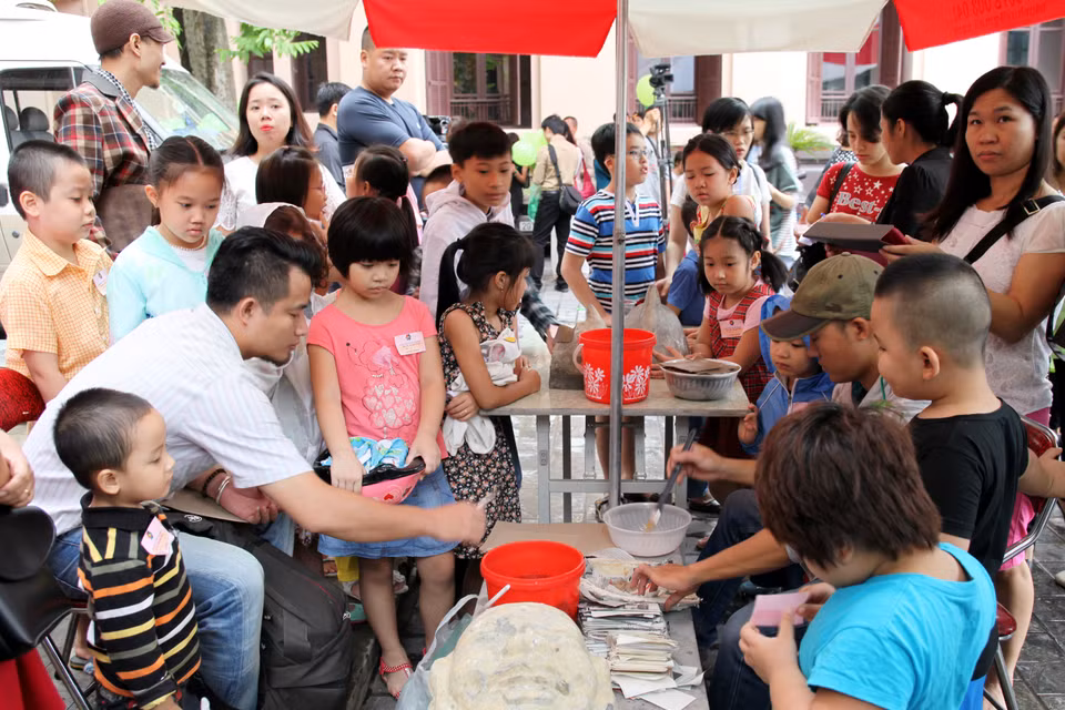 Các nghệ nhân bồi những lớp giấy bản chồng lên nhau bằng hồ nếp để tạo ra một chiếc mặt nạ vừa nhẹ, vừa cứng.(Ảnh: Doãn Đức/Vietnam+)