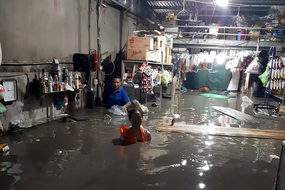Người dân phường Hà Khánh, thành phố Hạ Long, đau xót khi hàng hóa ngập trong nước do mưa lớn đêm 25/8. (Ảnh: TTXVN phát)
