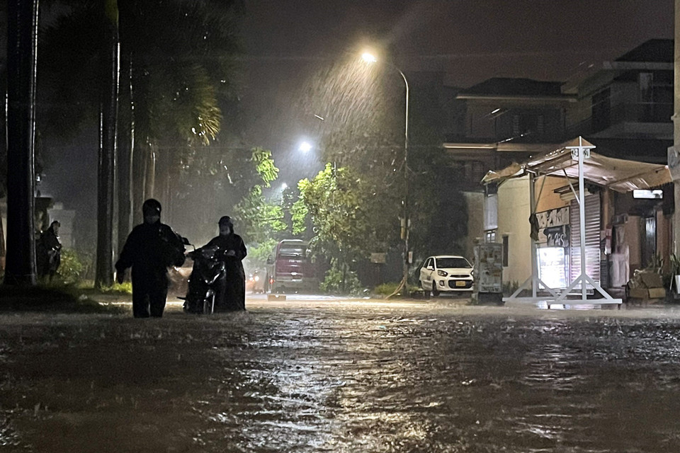 Do mưa lớn tại Hạ Long, nước dâng cao, nhiều đoạn đường bị ngập sâu, người dân phải dắt xe do chết máy. (Ảnh: TTXVN phát)