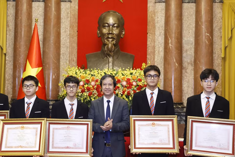 Bộ trưởng Bộ Giáo dục và Đào tạo Nguyễn Kim Sơn trao Bằng khen của Thủ tướng Chính phủ cho học sinh đoạt giải các cuộc thi Olympic và Khoa học kỹ thuật quốc tế năm 2022. (Ảnh: Thống Nhất/TTXVN)