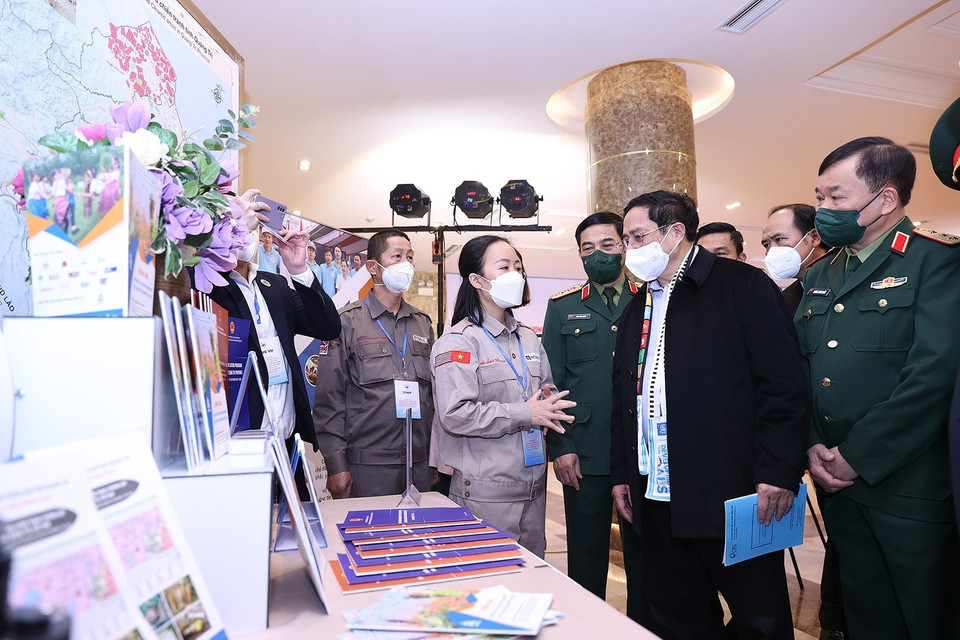 Hình ảnh Thủ tướng Phạm Minh Chính tham quan trưng bày ảnh, sách, báo, tuyên truyền về phòng tránh bom mìn. (Ảnh: Dương Giang/TTXVN)