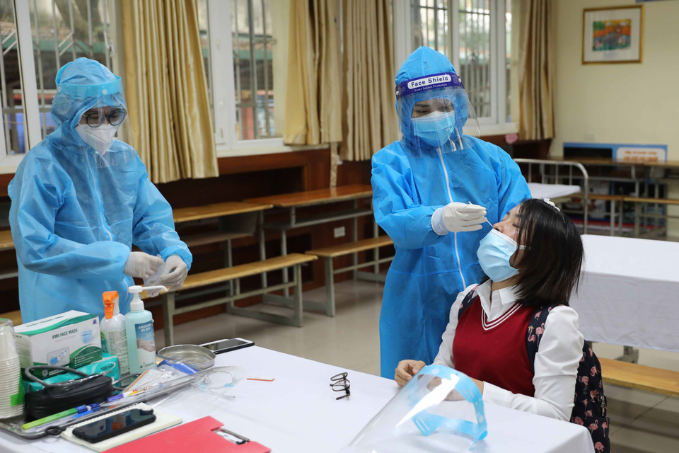 Nhân viên y tế phường lấy mẫu test nhanh lần hai để khẳng định. (Ảnh: Thanh Tùng/TTXVN)