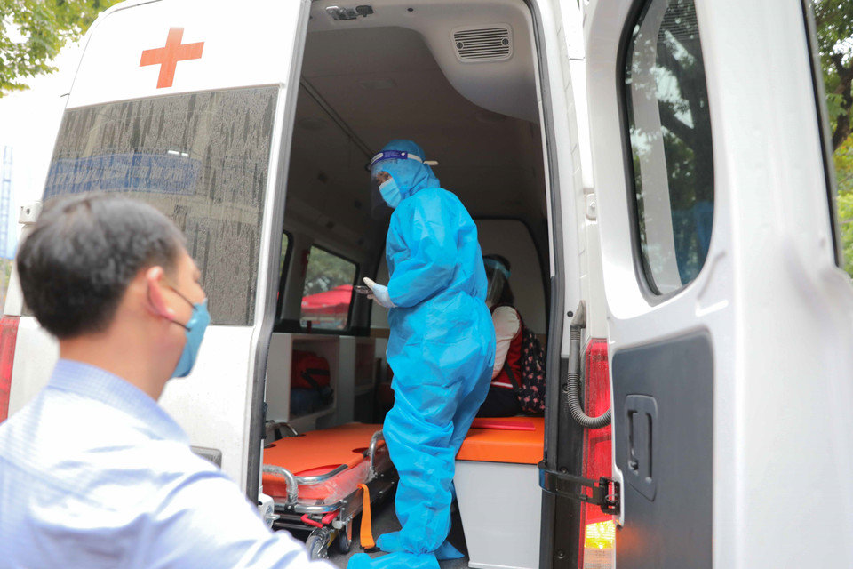 Sau khi học sinh có kết quả dương tính lần 2 sẽ được xe cứu thương chuyển đi điều trị theo quy định. (Ảnh: Thanh Tùng/TTXVN)