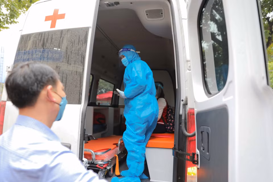 Sau khi học sinh có kết quả dương tính lần 2 sẽ được xe cứu thương chuyển đi điều trị theo quy định. (Ảnh: Thanh Tùng/TTXVN)