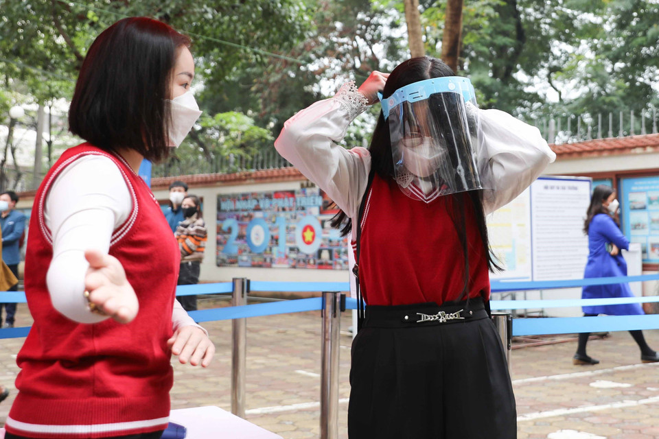 Học sinh khi đo thân nhiệt có nhiệt độ cao được hướng dẫn vào phòng cách ly y tế của trường để kiểm tra. (Ảnh: Thanh Tùng/TTXVN)