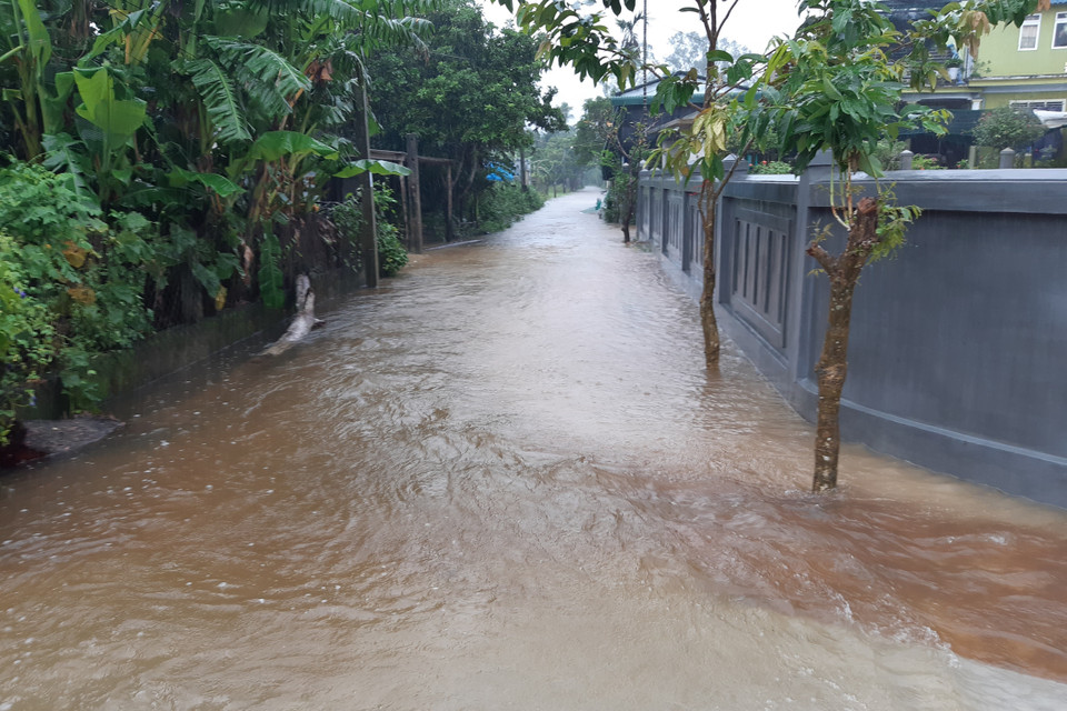 Nhiều đoạn đường vùng thấp trũng bị ngập cao, nước chảy siết. (Ảnh: Mai Trang/TTXVN)