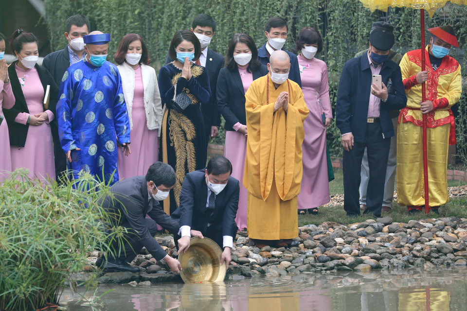 Thả cá chép theo nghi thức truyền thống. (Ảnh: Thanh Tùng/TTXVN)