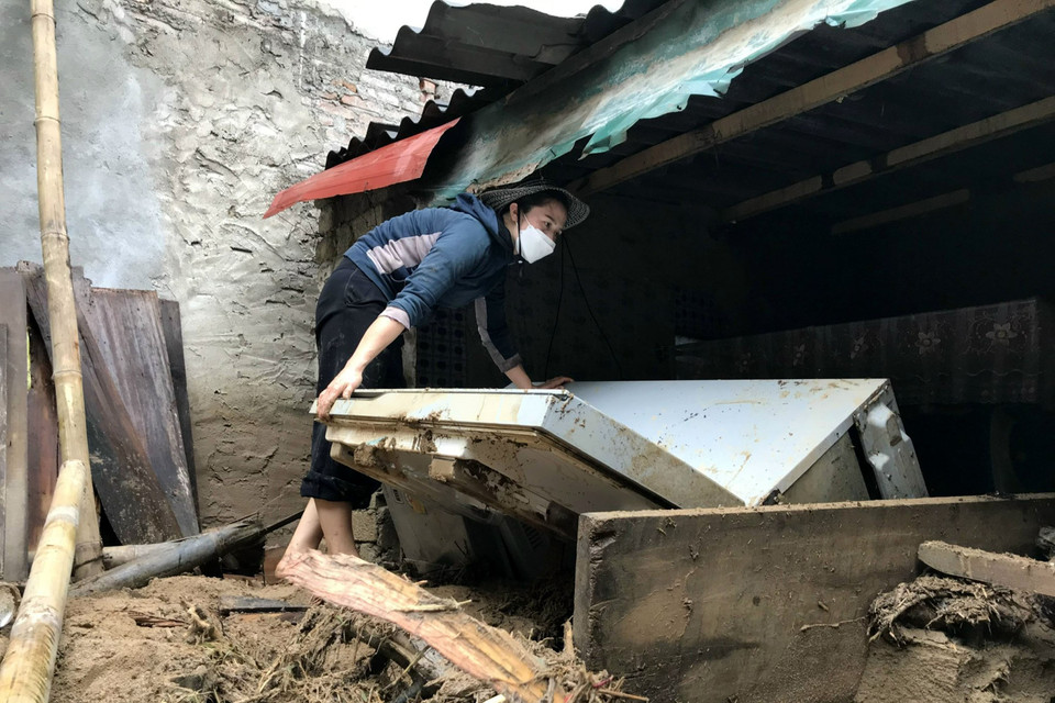 Nước đang rút, người dân bắt đầu dọn dẹp, khắc phục hậu quả mưa lũ. (Ảnh: Văn Tý/TTXVN)